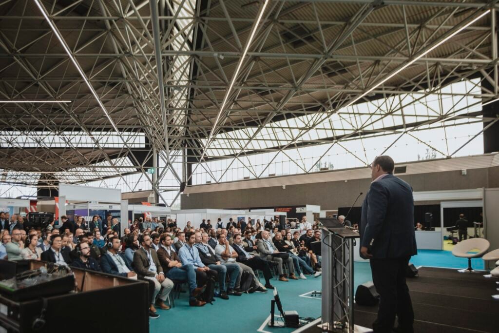 A presenter speaking to an engaged audience at The Blockchain Expo North America