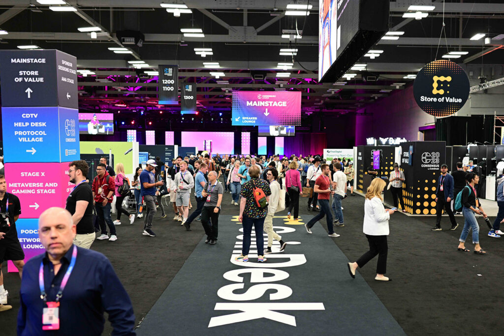 Attendees milling around various booths and stages at the bustling Consensus conference